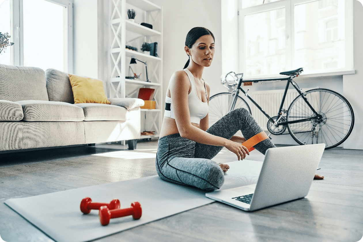 doing everything right beautiful young woman sports clothing using laptop while exercising home