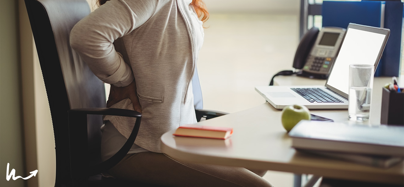 Person in an office chair holding their back in pain.