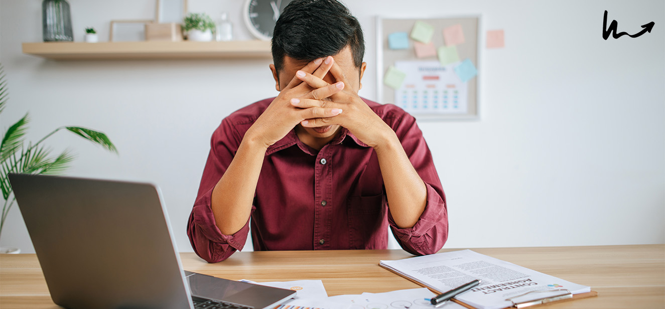 man working in the office with his hands covering his face
